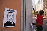 Jose Gomez of Hayward, scrubs graffiti from a building in downtown, where thousands of protesters gathered to honor George Floyd in downtown Oakland, Calif., on Thursday, June 4, 2020