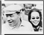 [Dr. King and wife Coretta, smiling, surrounded by people]