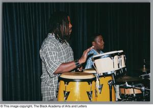 Photograph of two men playing instruments on stage