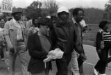 Dick Gregory and other marchers during the 20th anniversary reenactment of the Selma to Montgomery March, probably in rural Dallas or Lowndes County, Alabama.