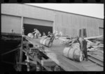 Negro stevedores "snaking" drums down ramp to boat, New Orleans, Louisiana