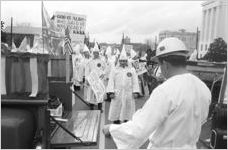 Klansmen standing behind two pickup trucks during a Ku Klux Klan rally in Montgomery, Alabama.