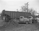 Employees of Flowers Coal Company in Montgomery, Alabama, loading coal from a railroad car.