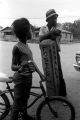 Diane Foster and a young man beside a concrete street sign in front of Pugh's Superette on Foster Street in Newtown, a neighborhood in Montgomery, Alabama.