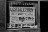 Advertisement for Lester Young and His California Playboys, hanging in the window of a the Palm Caf, in Harlem.