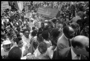 Speakers arriving at the 25th Anniversary of the March on Washington Jesse Jackson, Coretta Scott King (front center), Joseph Lowery (to right of King), Michael Dukakis (right), and other speakers approach the stage through the crowd