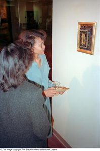 Two women viewing artwork at Living Legends exhibition