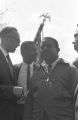 Fred Shuttlesworth, Ralph Abernathy and others talking in the street at Martin Luther King, Jr.'s funeral.