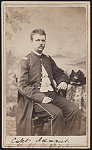 [Second Lieutenant Enoch G. Adams of Co. D, 2nd New Hampshire Infantry Regiment and Co. D, 1st U.S. Volunteer Infantry Regiment in uniform in front of painted backdrop]