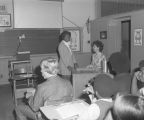 Student standing at the teacher's desk in a classroom at Goodwyn Junior High School at 209 Perry Hill Road in Montgomery, Alabama.