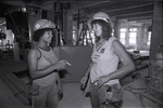 Women construction workers talking at a Community Redevelopment Agency project site, Los Angeles, 1981