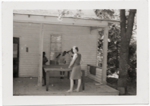 Marjorie Merrill playing ping pong with children on porch of Rust Avenue house rented by the Congress of Federated Organizations (COFO)