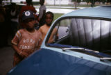 Children standing next to Volkswagen automobile