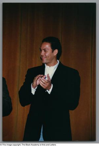 Photograph of a man clapping and smiling