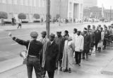 Fred Shuttlesworth and other civil rights demonstrators confronting a police officer during a protest march in downtown Birmingham, Alabama.