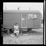 Arlington, Virginia. FSA (Farm Security Administration) trailer camp project for Negroes. Girl occupant preparing vegetables outside of a single type trailer