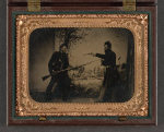 [Two unidentified soldiers in Union uniforms posing with bayoneted Springfield Model 1861 rifled musket with attached bayonet,  knife, and Colt Model 1851 Navy revolver in front of painted backdrop showing landscape with camp]