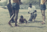 Injured athlete in the grass during the annual high school track meet of the Alabama Interscholastic Athletic Association, probably held in Montgomery.