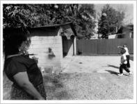 Sandra Jones watches as her son Brandon and nephew Brian Jones play basketball