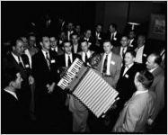 Company executives sing-along, with African-American accordian player. Coca-Cola Company party at the Capitol City Club, Atlanta, Georgia, March 18, 1954