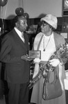 Crenshaw Chamber of Commerce representative presenting an award to Mrs. Campbell, Los Angeles, 1985