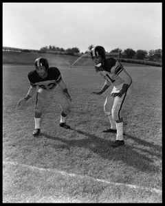 Two Football Players Standing in Athletic Stances