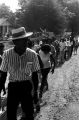 Group marching down an unpaved road in Prattville, Alabama, during a demonstration sponsored by the Autauga County Improvement Association.