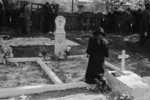 Negro women praying at grave of son in cemetery at New Roads, Louisiana on All Saints' Day