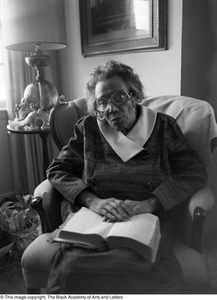 Photograph of Mable Chandler holding a book with a thumb index