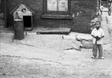 Jasper Wood Collection: Boy standing near dog house