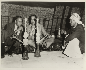 Duke Ellington and Paul Gonsalves with hookah and drinking tea in Ctesiphon, Iraq : black-and-white photoprint