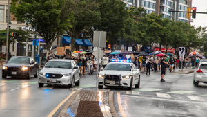 Police vehicles in front of Black Lives Matter marchers