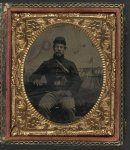 [Unidentified soldier in Union shell jacket and forage cap with handgun in front of painted backdrop showing military camp]