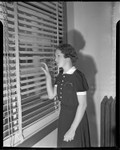 Thumbnail for Cult victim Delight Jewett peering through blinds in U.S. Attorney Fleet Palmer's office, Los Angeles, 1937