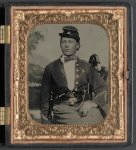 Thumbnail for [Unidentified soldier of the 26th New York Infantry Regiment with revolver in front of painted backdrop showing camp scene]