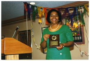 Woman in Green Holding Plaque at Service to Youth Award Program