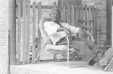 Man sitting on a lawn chair on the front porch of a brick house in Newtown, a neighborhood in Montgomery, Alabama.