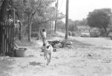 Boy and dog in the yard beside a dirt road in Newtown, a neighborhood in Montgomery, Alabama.