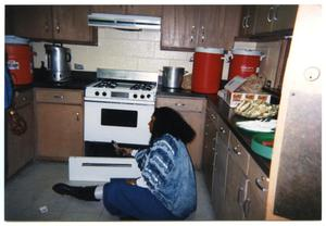 Woman Seated on Floor in Kitchen