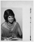 [Katherine Dunham, dancer, half-length portrait, facing slightly right, seated at table, eating]