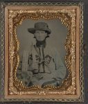 [Unidentified soldier in Confederate cavalry uniform with D-guard Bowie knife, revolver, canteen, and sign reading Jeff Davis and the South!]