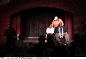 Performer and man sitting on stage