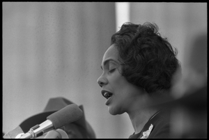 Coretta Scott King addressing the Solidarity Day crowd at the Poor People's March on Washington, speaking against the War in Vietnam Portrait in profile, at the microphones