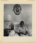 [African American woman sitting in her living room, East Side, Buffalo]