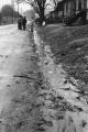 Children talking while standing on a muddy road.