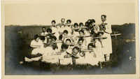 Group of men and women eating watermelon