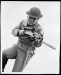 [Untitled photo shows: heavyweight boxing champion Joe Louis charging with bayoneted rifle]