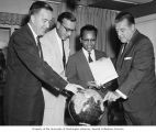 Senators Henry M. Jackson and Warren G. Magnuson with others looking over exhibition literature for the Seattle Century 21 Exposition and pointing to a globe, Washington, D.C., 1962