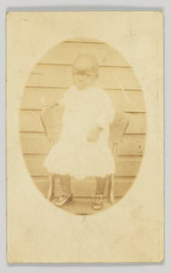 Photographic postcard featuring an oval portrait of a young child