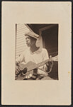 [Bill Tatnall, half-length portrait, seated, facing left, playing guitar, Frederica, Georgia]